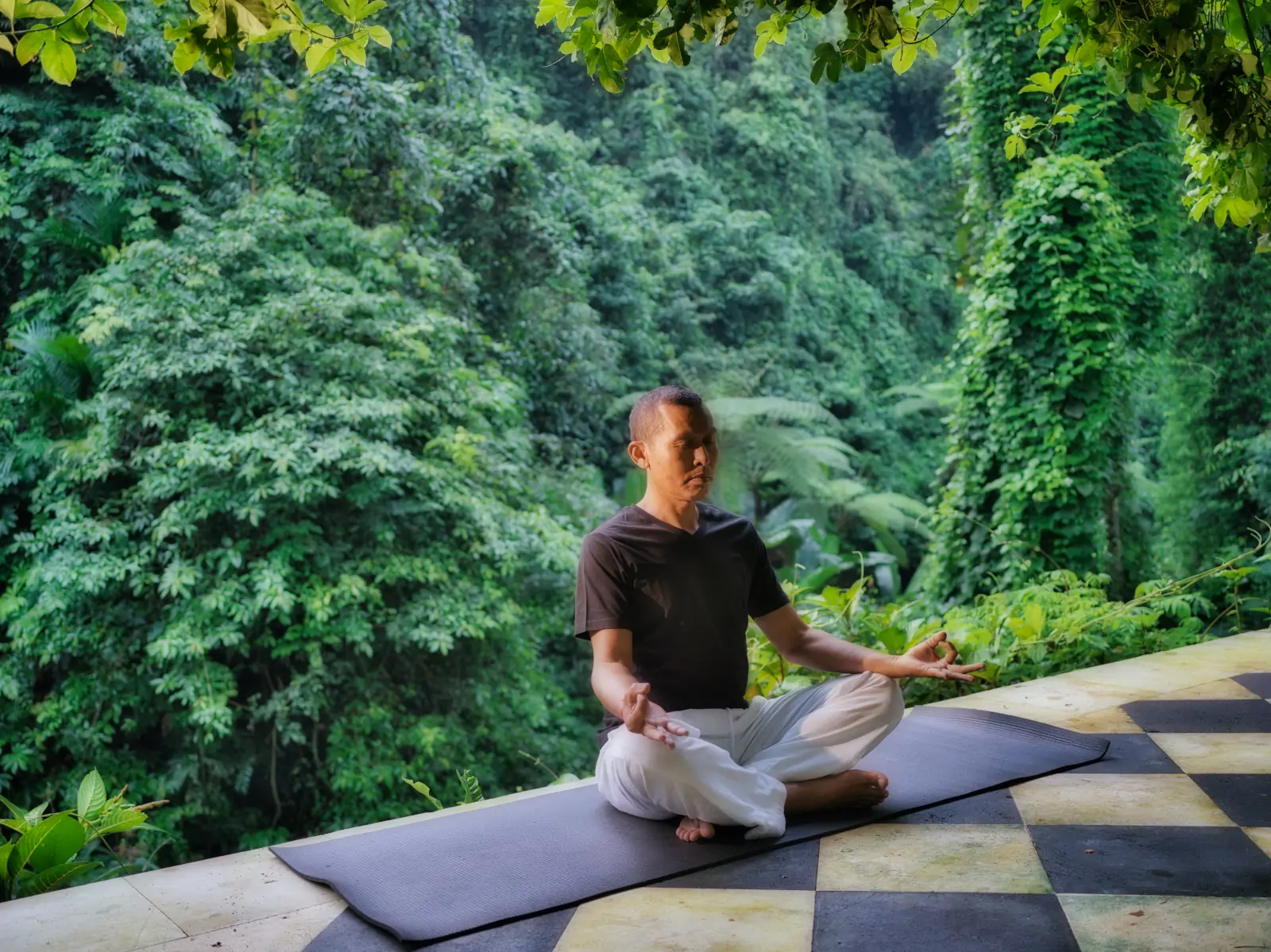 Meditation at Hanging Gardens of Bali overlooking rainforest during spiritual retreat