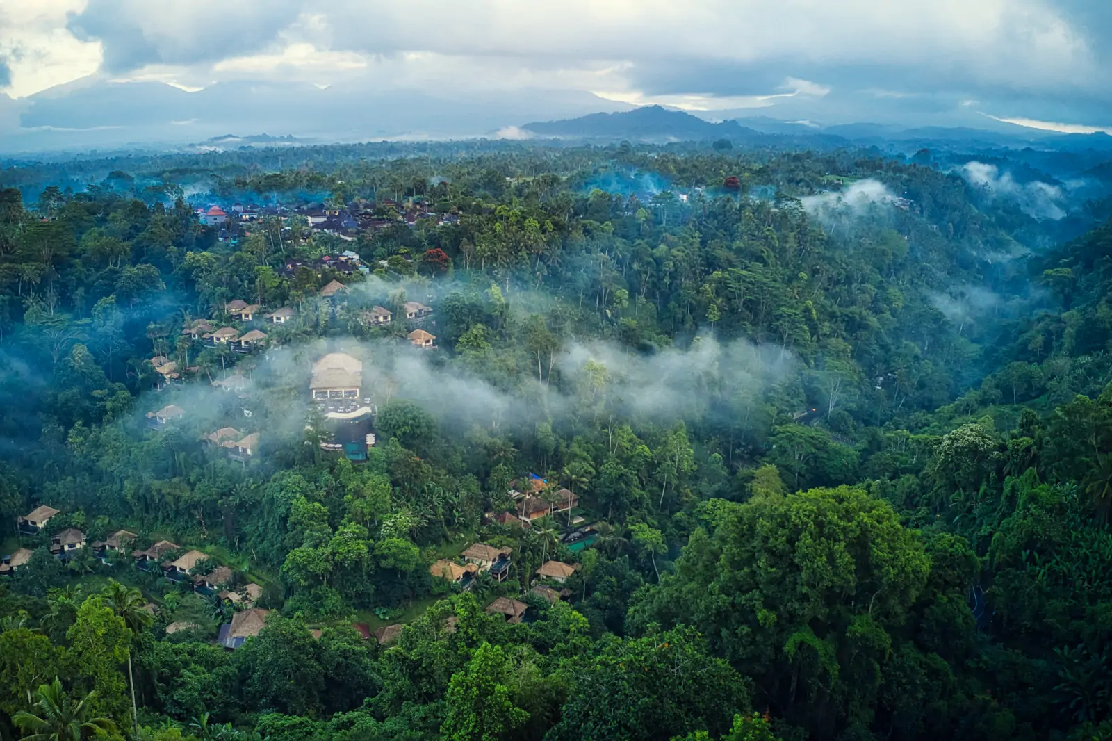 Hanging Gardens of Bali villa terrace above rainforest canopy with morning mist in Ubud