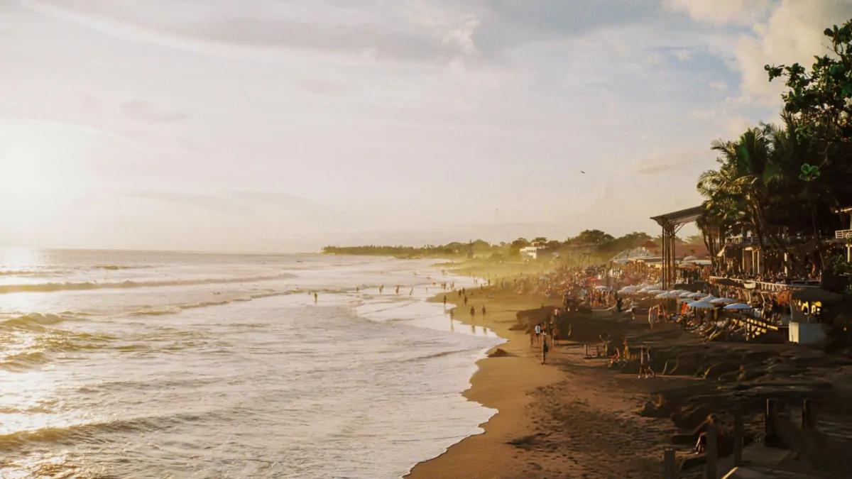 Bali beach crowded during summer season with tourists enjoying sunny dry season weather