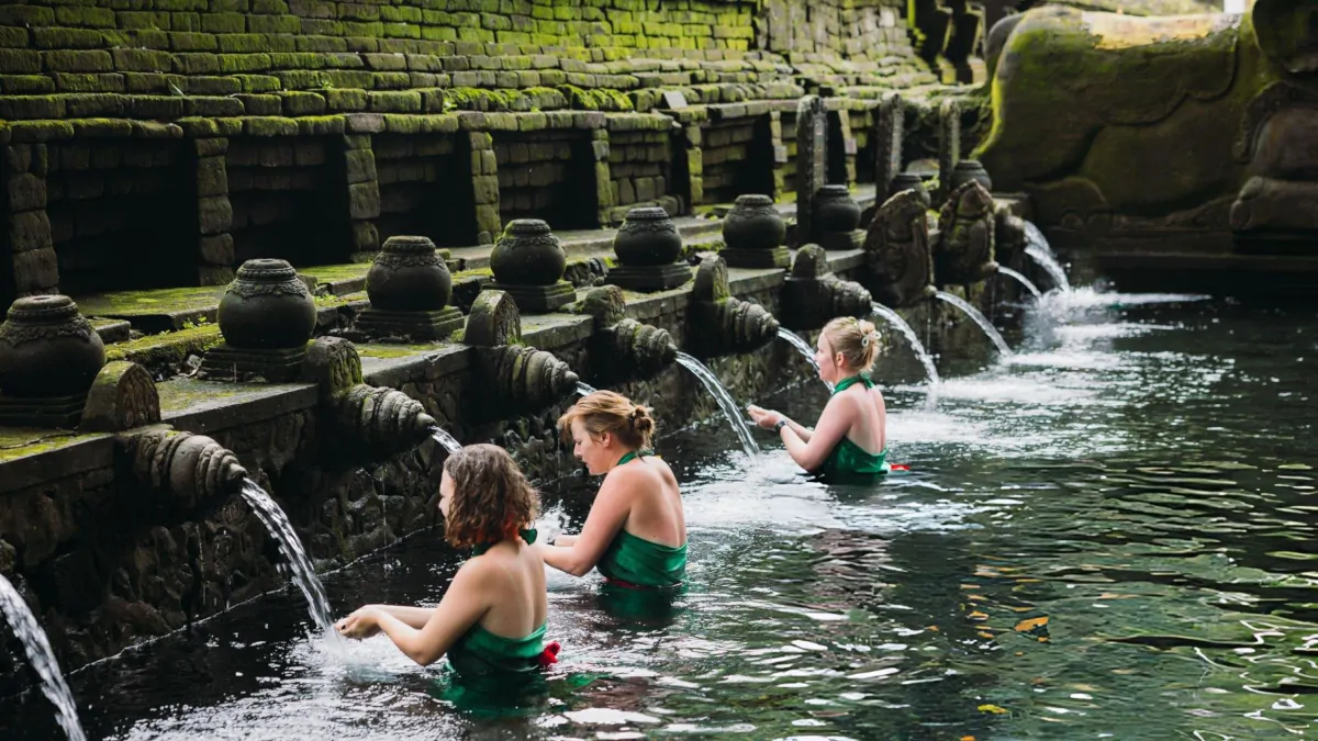Balinese water blessing ceremony melukat with temple fountains and traditional dress in Ubud
