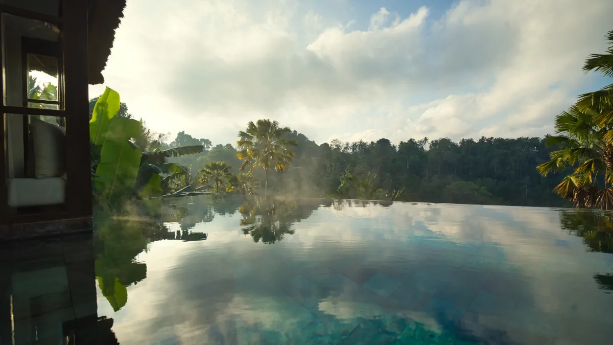 Hanging Gardens of Bali infinity pool overlooking rainforest valley in calm morning light Ubud