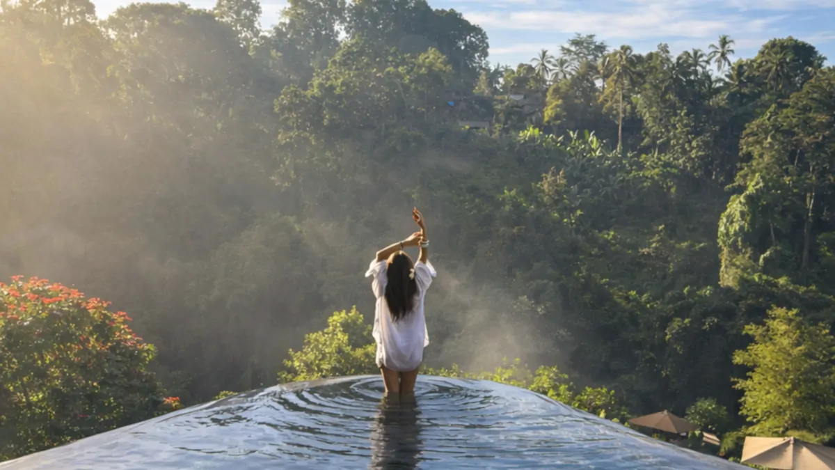 Hanging Gardens of Bali infinity pool overlooking rainforest valley during Bali summer dry season June July August